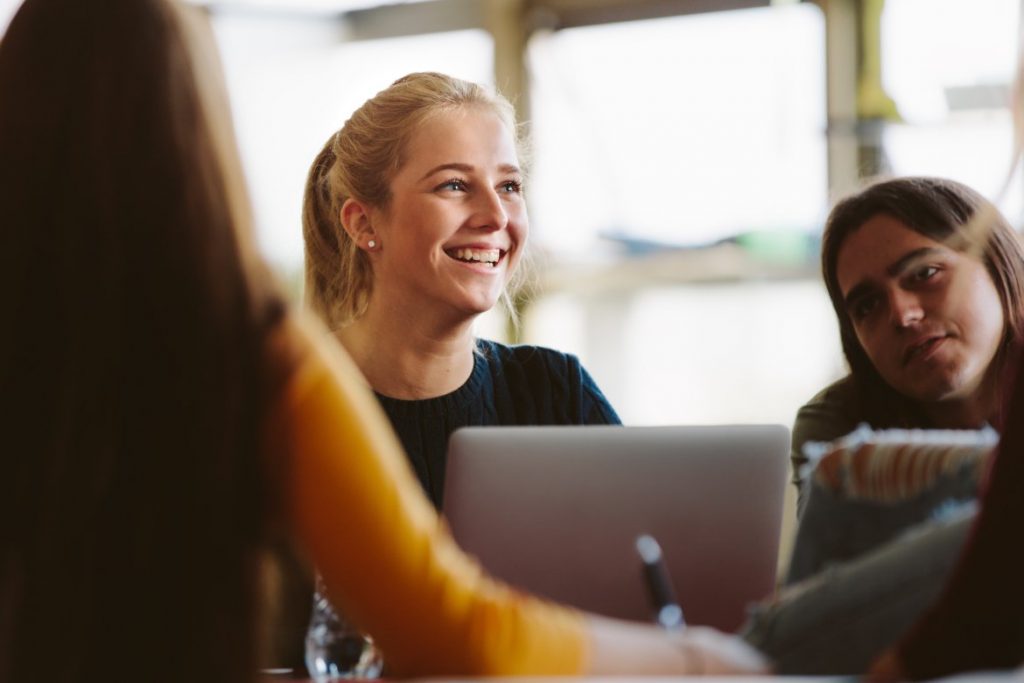 girl sitting at her computer looking up and smiling