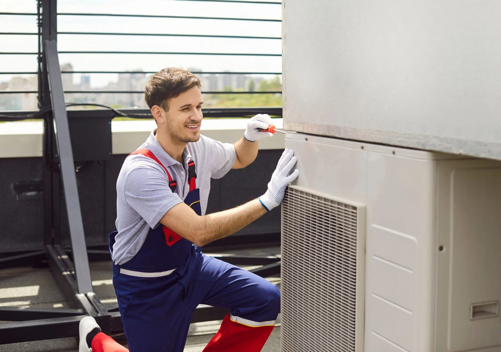 hvac tech kneels next to an outdoor ac unit